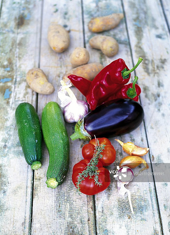 木面上的新鲜番茄、茄子、西葫芦、洋葱和土豆图片素材