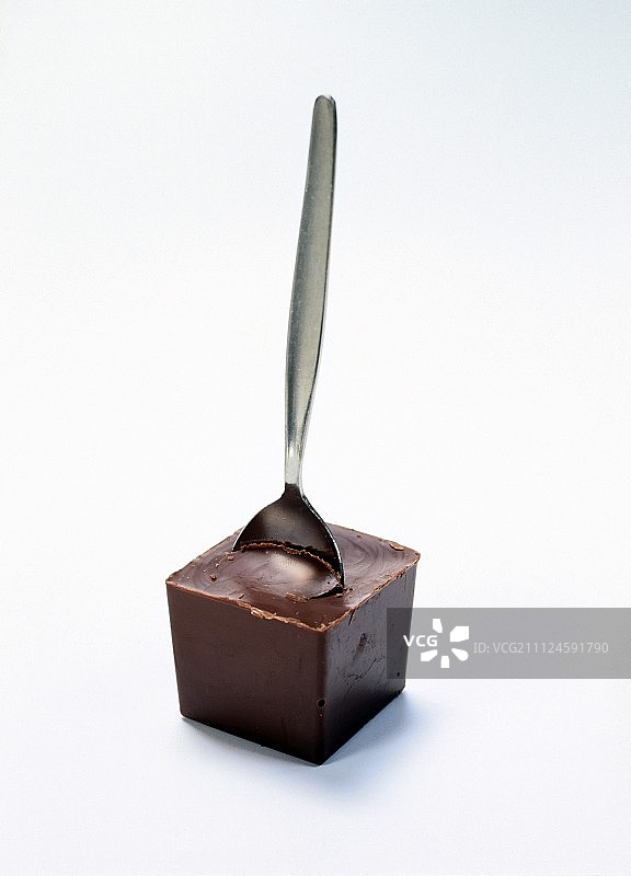 白色背景上的巧克力块和银色茶匙图片素材