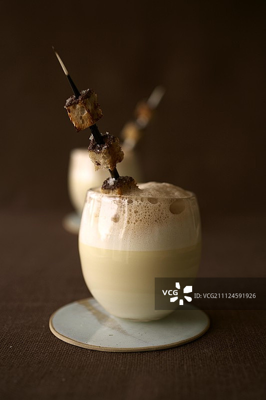 玻璃杯里的芹菜汤配奶沫和面包丁图片素材