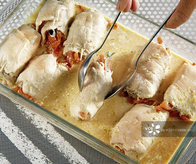 用勺子在烤盘中制作肉卷的特写图片素材