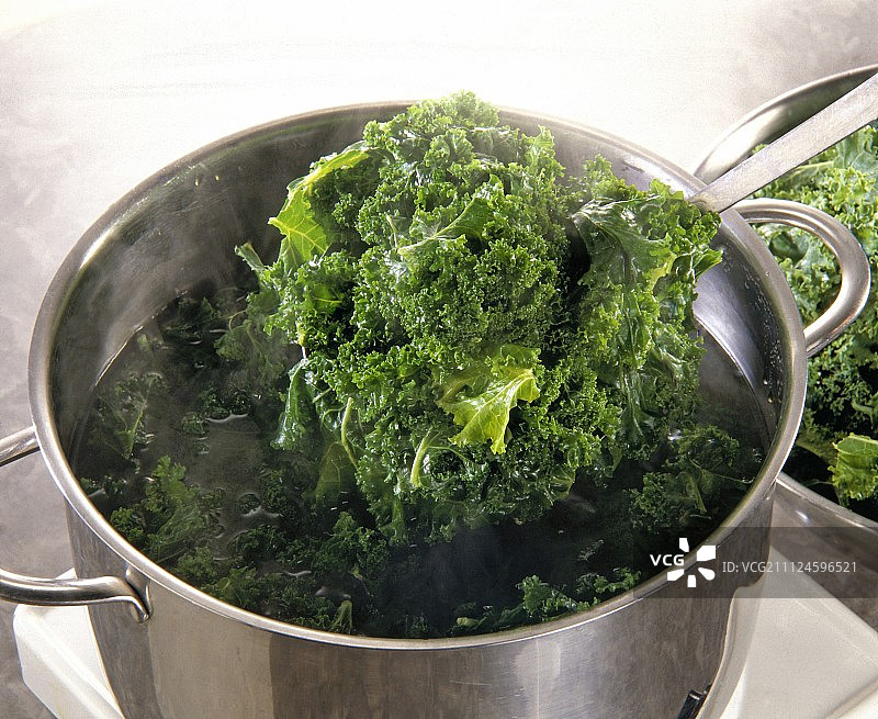 从锅里捞出的煮熟的羽衣甘蓝图片素材