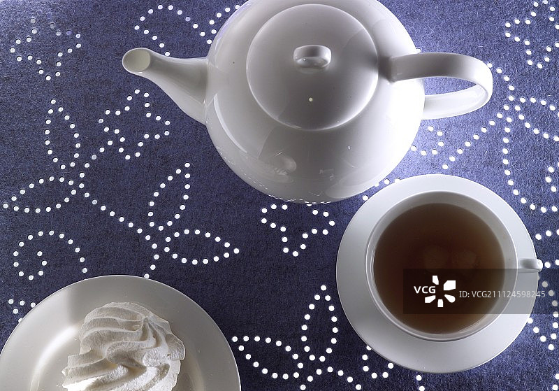 白色紫毯上的瓷茶壶套装图片素材