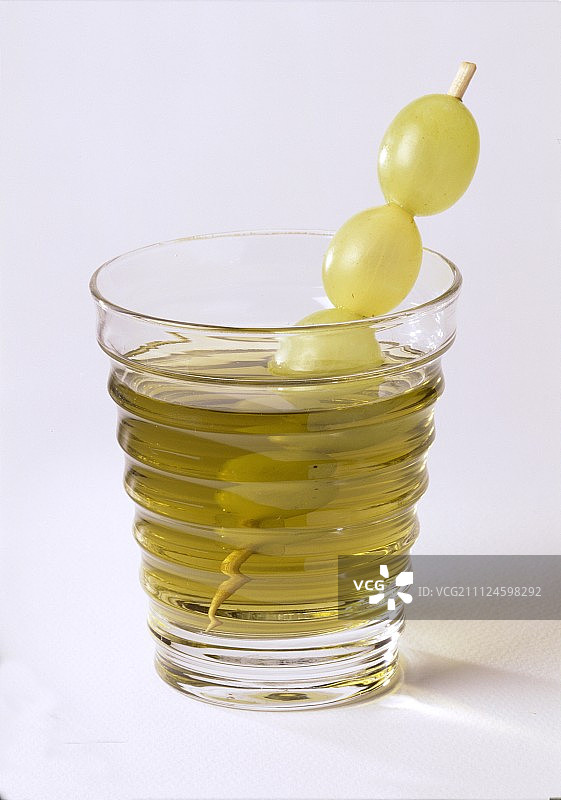 玻璃杯中用葡萄装饰的绿色荨麻饮品图片素材