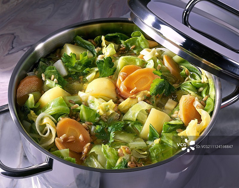 砂锅炖卷心菜特写，配有胡萝卜、土豆和芹菜图片素材