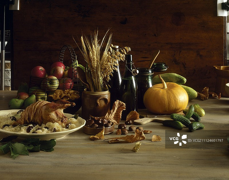 烤野鸡配酸菜、黄瓜、南瓜和栗子图片素材