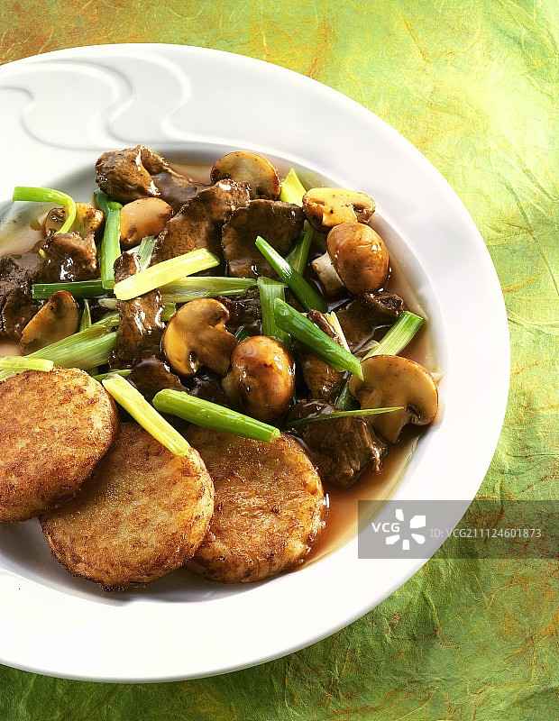 盘中烤韭葱、洋葱和蘑菇的特写图片素材