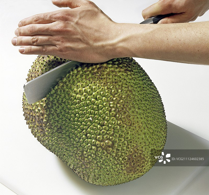 用切刀切菠萝蜜的手部特写，步骤 1图片素材