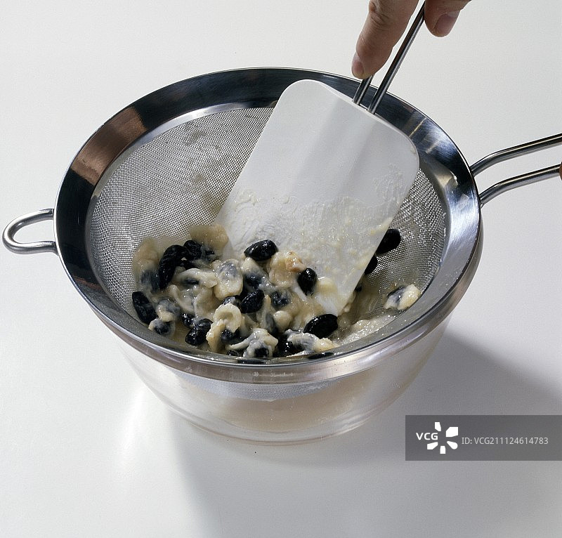 筛子里番荔枝的果肉和种子与橡胶刮刀图片素材