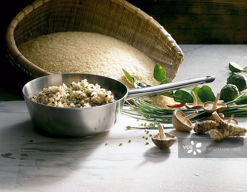 平底锅中的米饭与蘑菇、高良姜、韭菜和泰国青柠图片素材