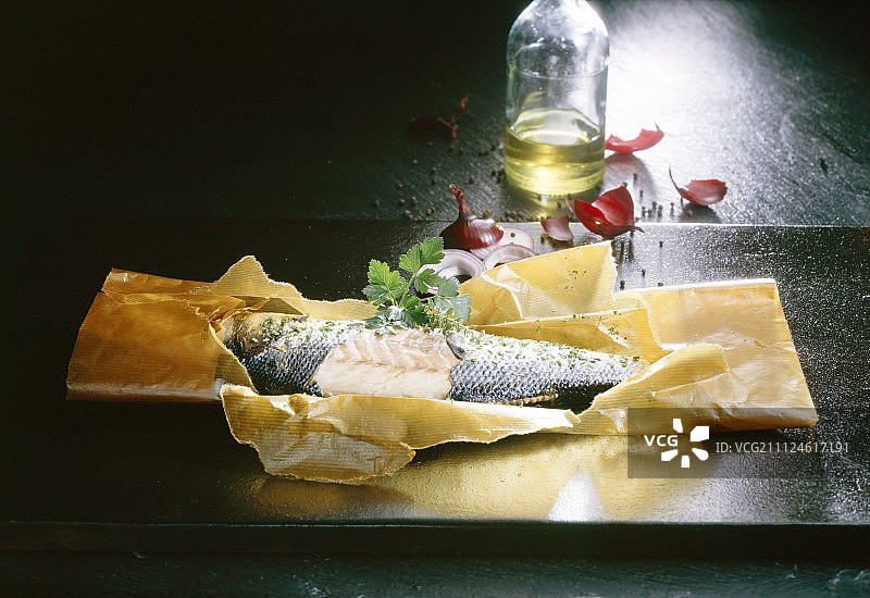 洋葱圈和油浸在烘焙纸里的鱼图片素材