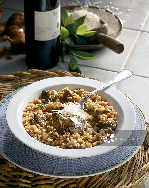 帕尔马干酪鹌鹑烩饭碗与红酒瓶图片素材