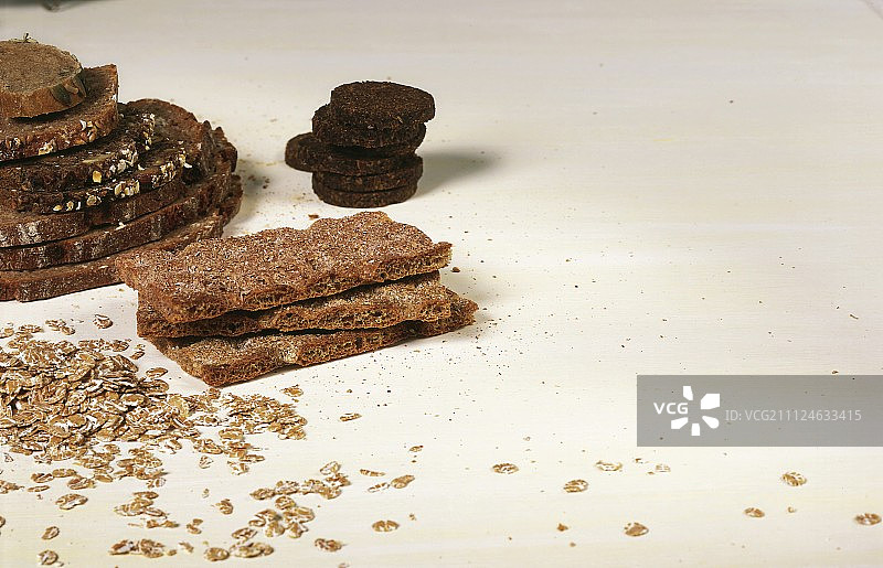 燕麦、黑麦粗面包和撒在白色背景上的南瓜籽图片素材