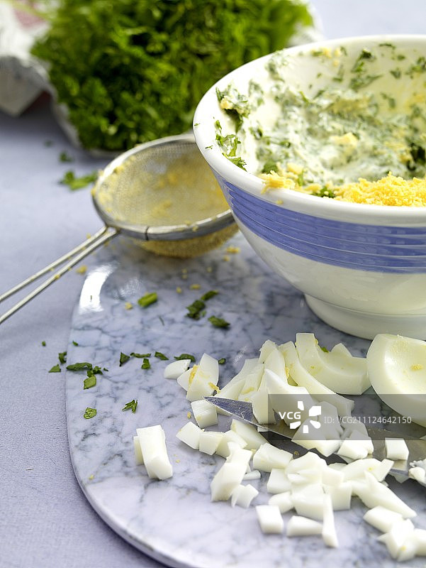 碗里的香草绿色酱汁、鸡蛋和筛子图片素材