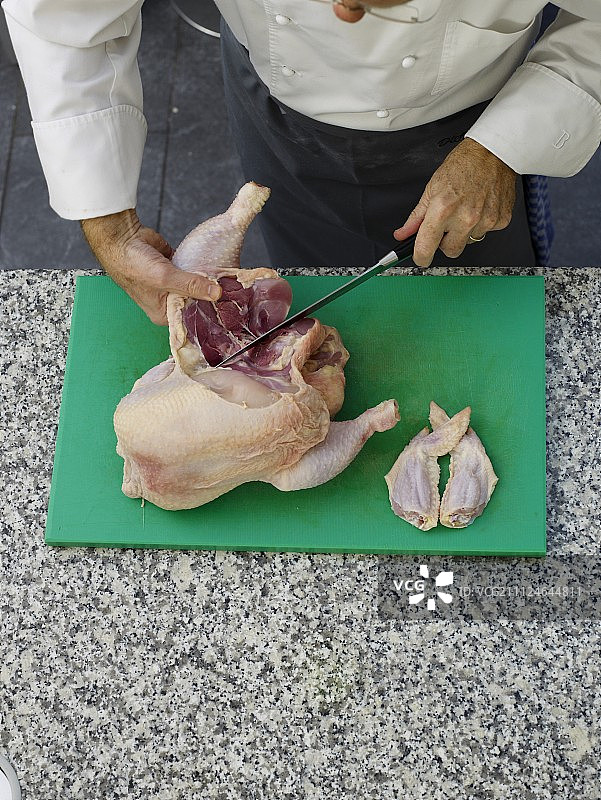 在砧板上切鸡肉图片素材