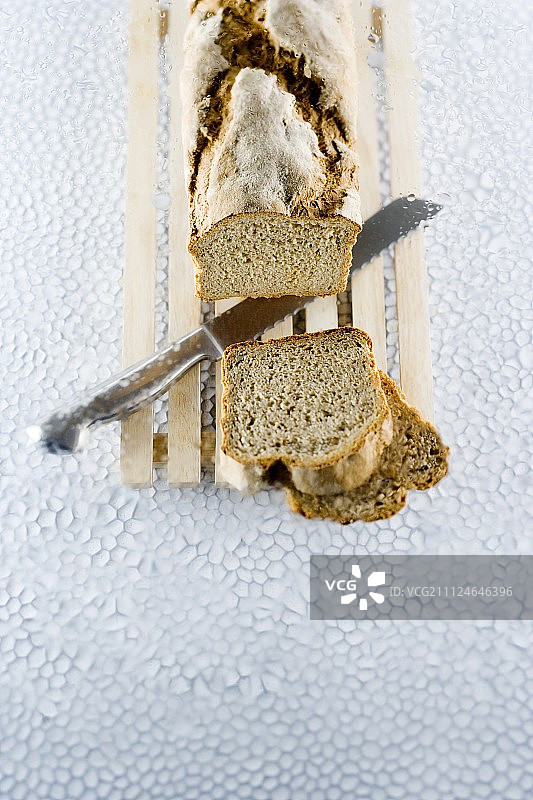 木板上的切片面包和刀图片素材