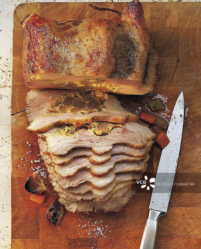木质表面上的小牛肉酿肉切片与刀具图片素材
