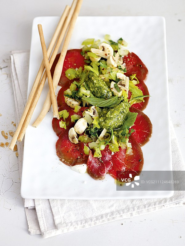 盘子里的牛肉薄片、蘑菇、香蒜酱和面包条图片素材