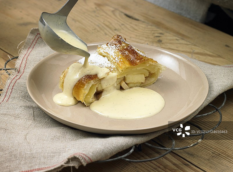 浇在苹果馅卷上的香草酱图片素材