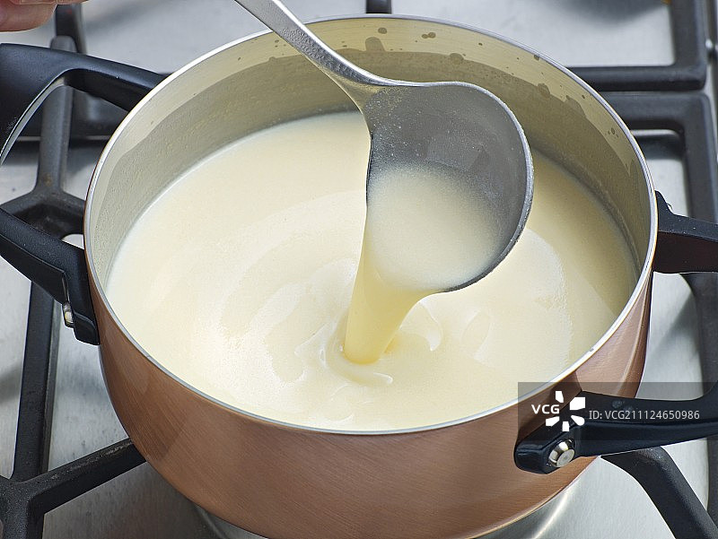 用勺子在平底锅中搅拌鲜奶油，步骤2图片素材