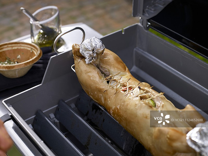 烤架上捆扎的填馅乳猪特写图片素材