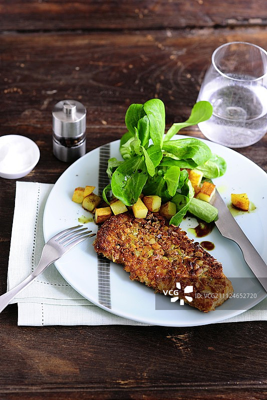 盘子上放着南瓜籽肉片和生菜图片素材