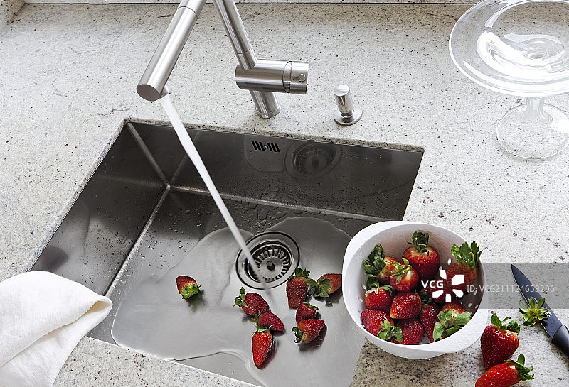 水龙头下清洗后的草莓图片素材