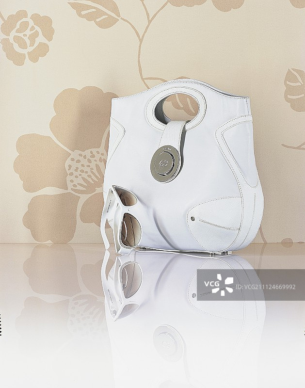 米色花卉背景上的包和太阳镜图片素材