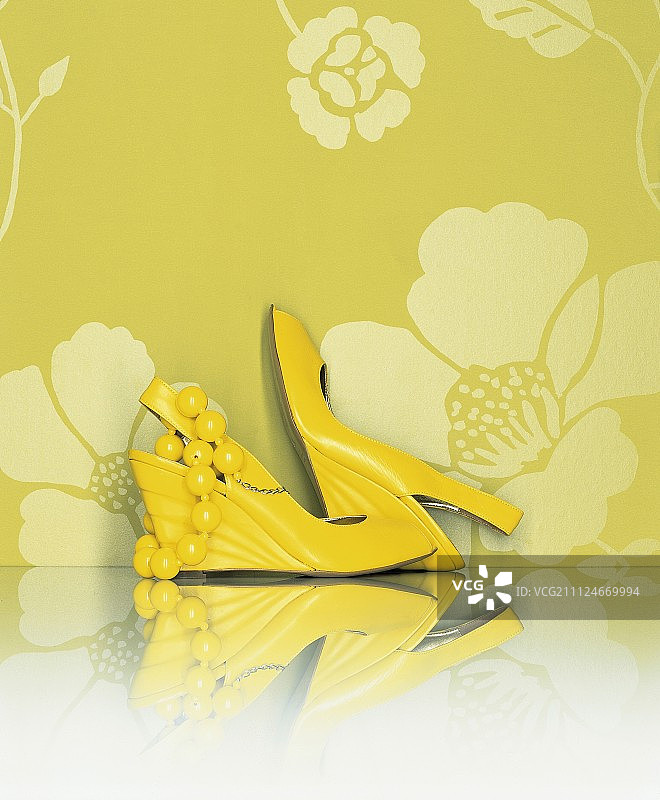 黄色凉鞋和珍珠项链在黄色花卉背景上图片素材