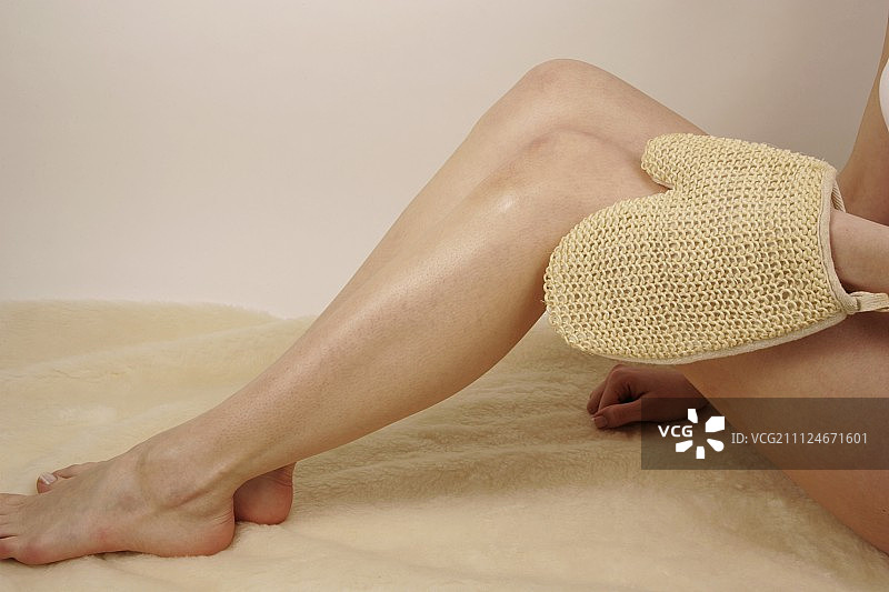 玛格达莱纳女人用手套擦拭腿部的特写图片素材