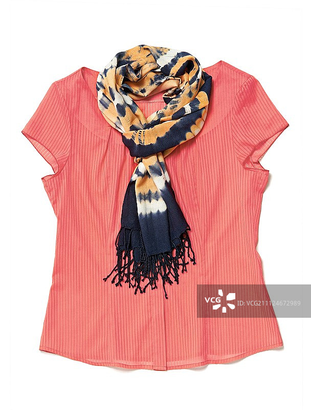 白色背景上带有蜡染布的橙色上衣特写图片素材