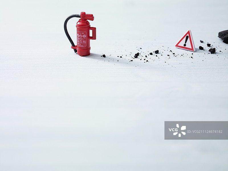 避免厨房事故的视觉隐喻：使用迷你灭火器和警告三角标志图片素材