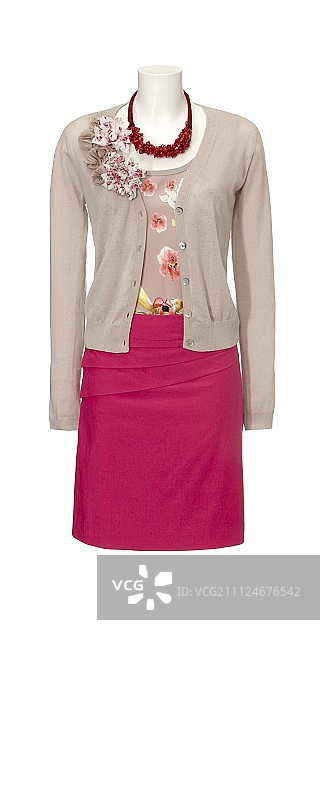 白色背景上人体模型身穿粉色裙子、碎花衬衫、米色开衫和链条图片素材