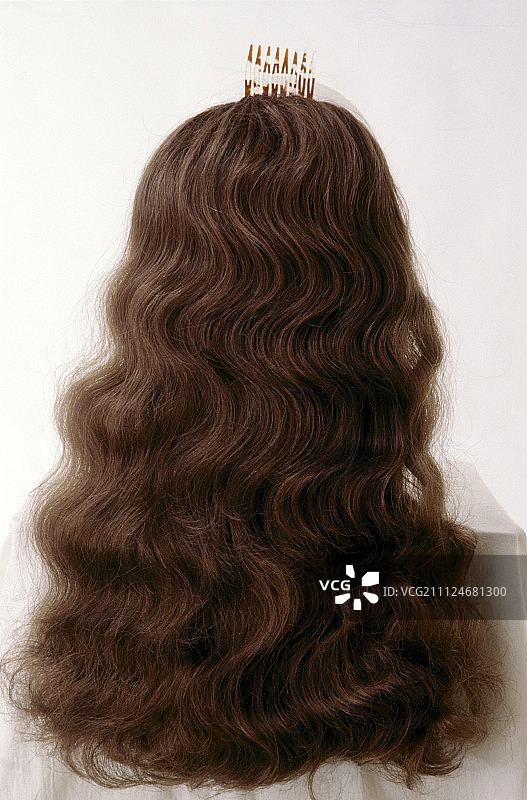 有着人造卷曲长发的棕发女人的背影图片素材