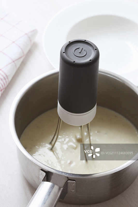 酱汁锅中电动搅拌器特写图片素材