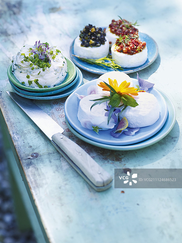 盘中三款鲜花浆果点缀的山羊奶酪菜肴图片素材