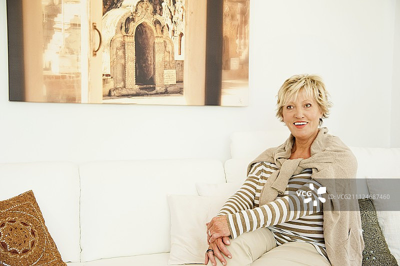一位穿着浅色衣服的老妇人坐在沙发上图片素材