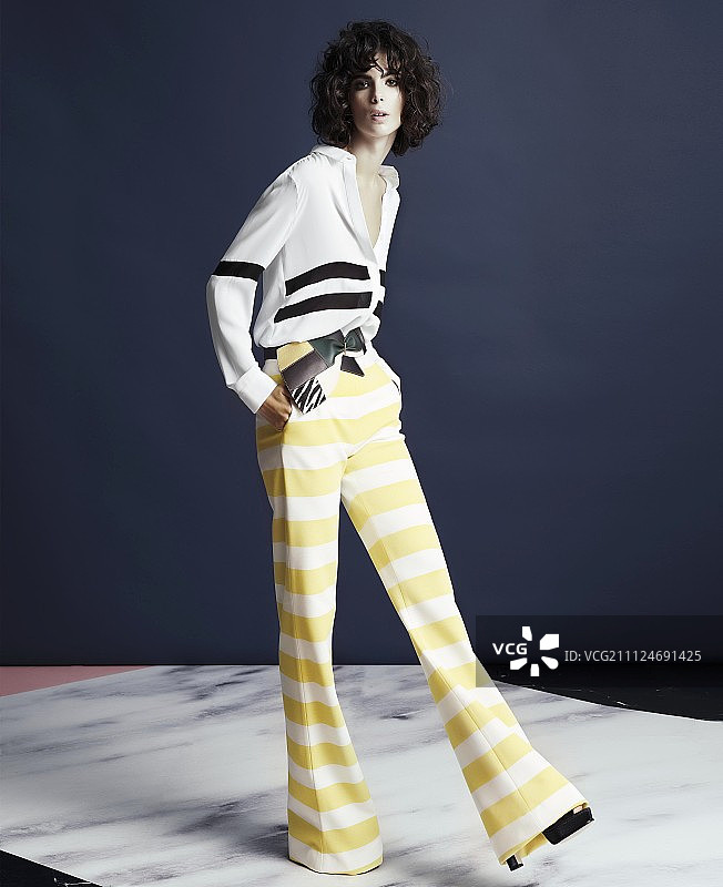 年轻女子身穿宽松衬衫和条纹喇叭裤图片素材