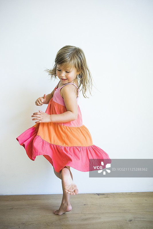 小女孩穿着褶皱连衣裙跳舞图片素材