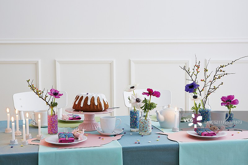 生日餐桌，有蛋糕、蜡烛和花瓶装饰图片素材