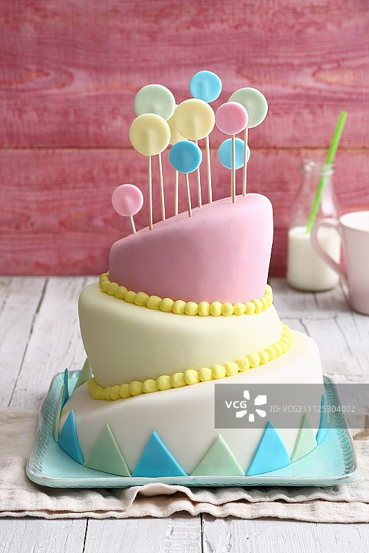 用彩色糖霜装饰的倾斜蛋糕图片素材