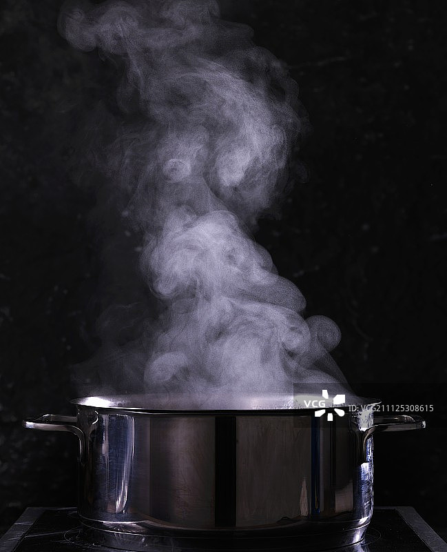 黑色背景下的沸腾水壶图片素材