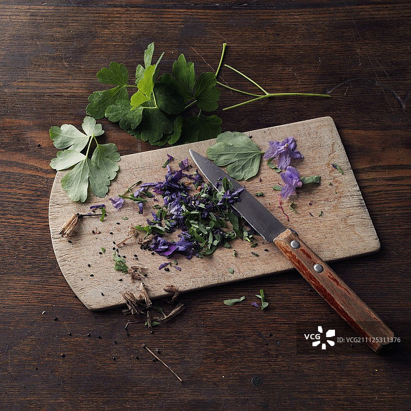 在木板上切碎的耧斗菜（用于制作希尔德加德·冯·宾根式的耧斗菜蜂蜜）图片素材