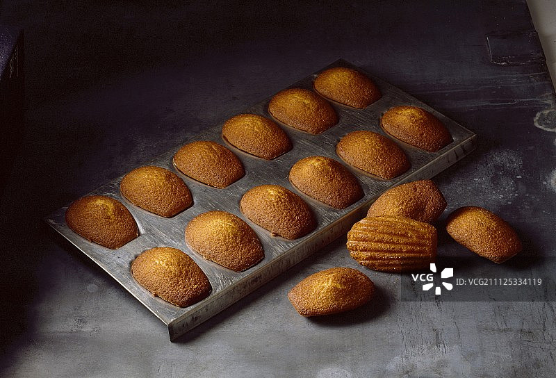 从烤盘中取出玛德琳蛋糕图片素材