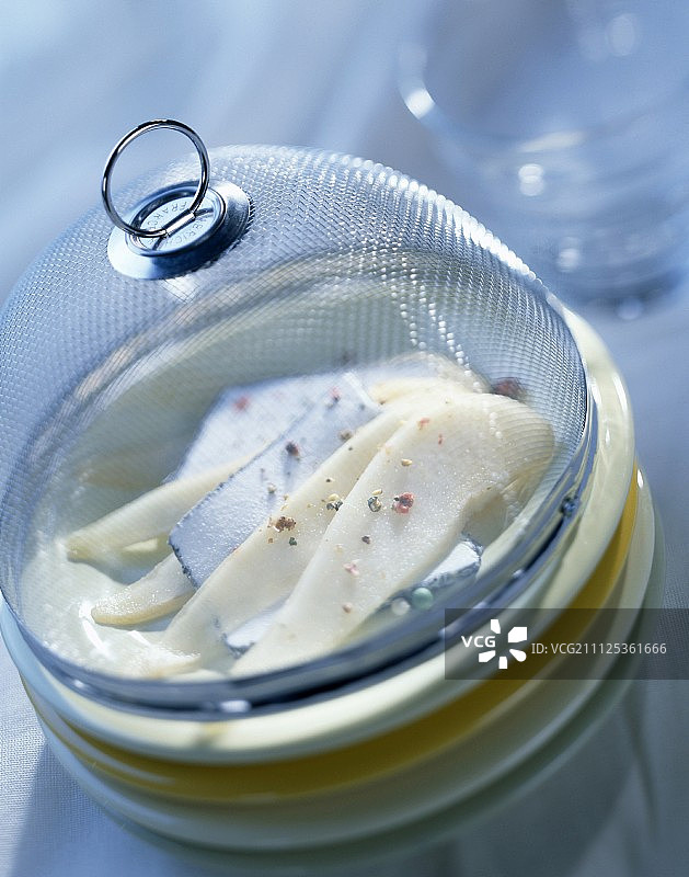 玻璃罩中的梨切片和瓦朗赛奶酪图片素材