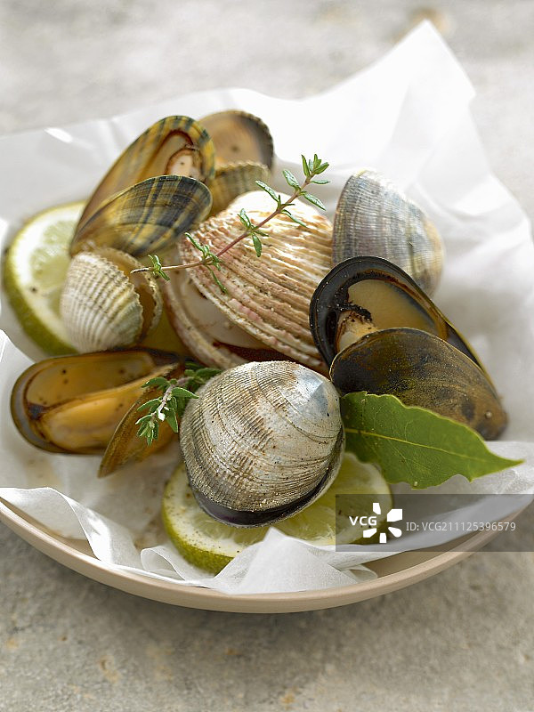 用蜡纸烹制的贝类配酸橙和百里香图片素材