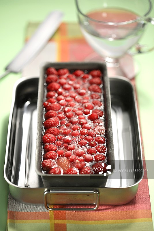 将明胶倒入夏日水果冻糕中图片素材