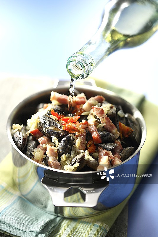 将白葡萄酒倒在贻贝上图片素材