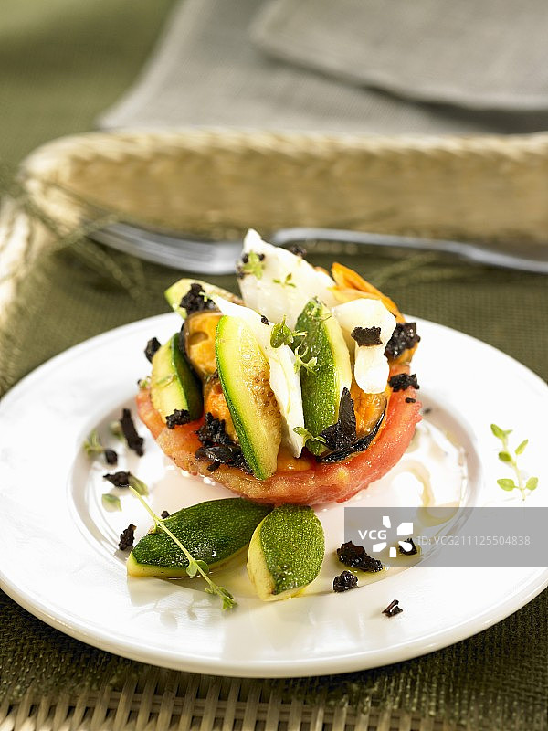 半个番茄与盐鳕鱼、西葫芦和黑橄榄图片素材