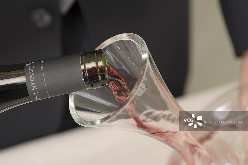 侍酒师用醒酒器醒一瓶红酒图片素材