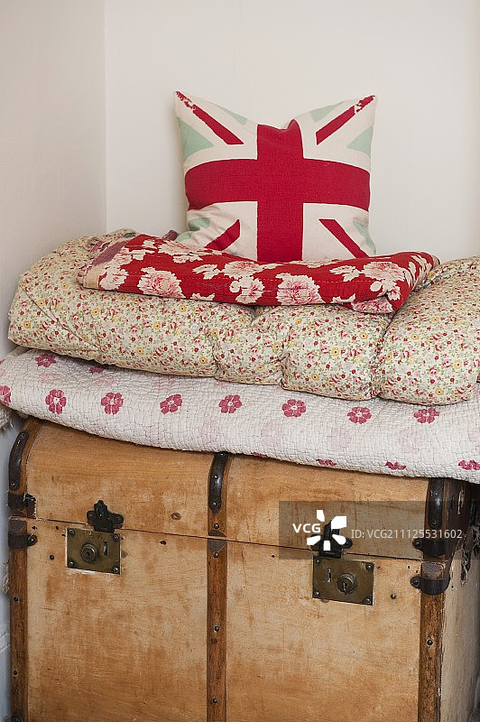 带有英国国旗图案的靠垫，堆放在木箱上的毯子上图片素材